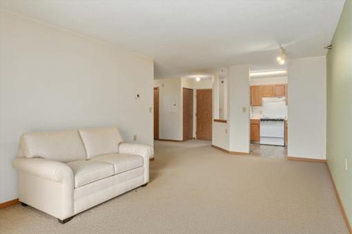 A white couch is in a large, empty room.