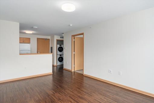 A room with a white wall and a brown door.