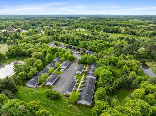A bird's eye view of a parking lot surrounded by trees.