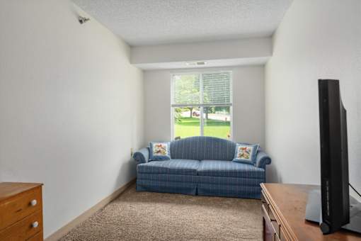 A living room with a blue couch and a flat screen TV.