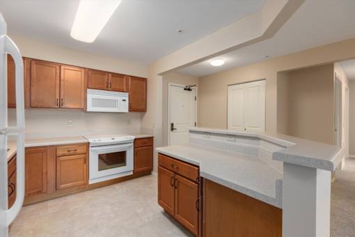 A kitchen with wooden cabinets and a white fridge.