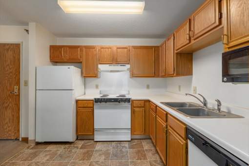 A kitchen with wooden cabinets and a white refrigerator.