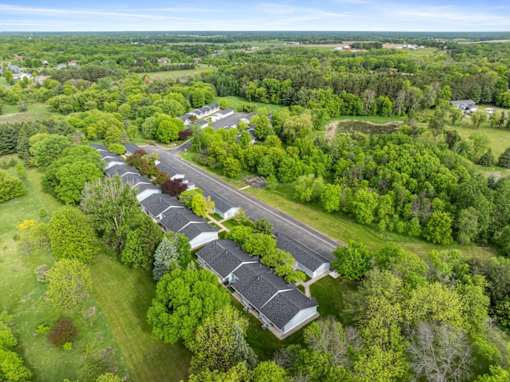 A long row of houses with trees in the front.