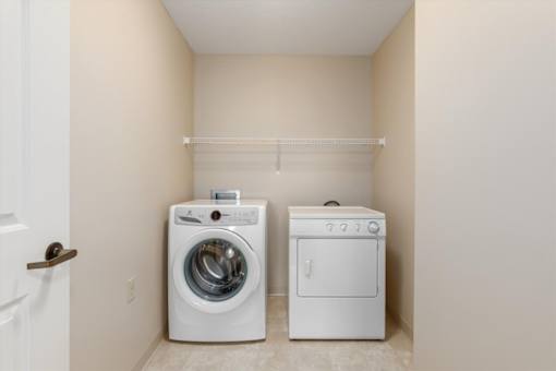 A white washing machine and dryer in a small laundry room.