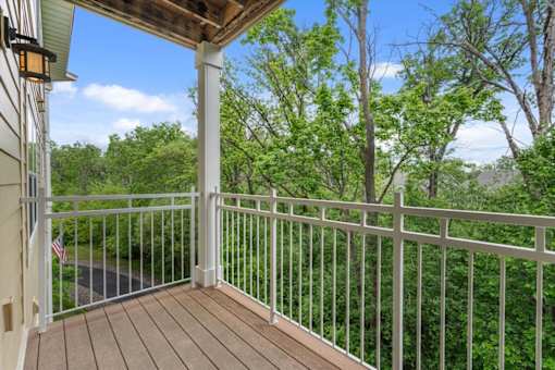 A balcony with a white railing and a flag hanging on the wall.