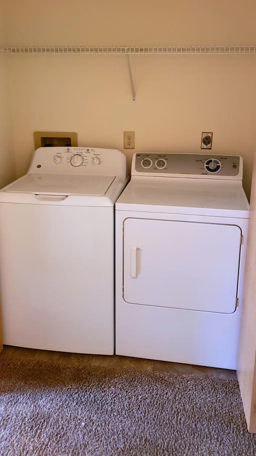 a washer and dryer in a room with a carpeted floor