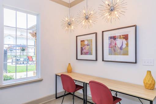 A table with two chairs and two hanging lights.