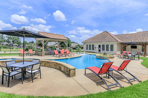 A poolside area with a table and chairs.