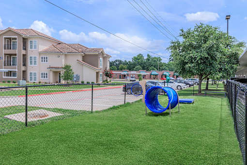 A playground with a blue slide and a baseball diamond.