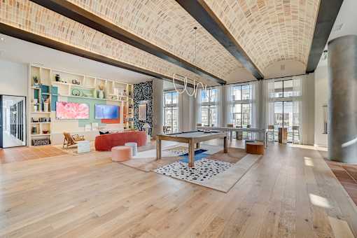 A spacious room with wooden floors and a large, open area with a sofa and a coffee table.