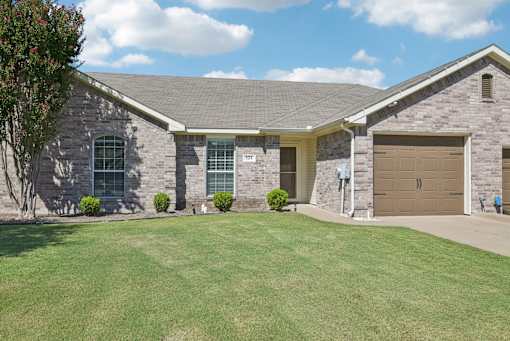 A house with a brown garage door and a grey roof.