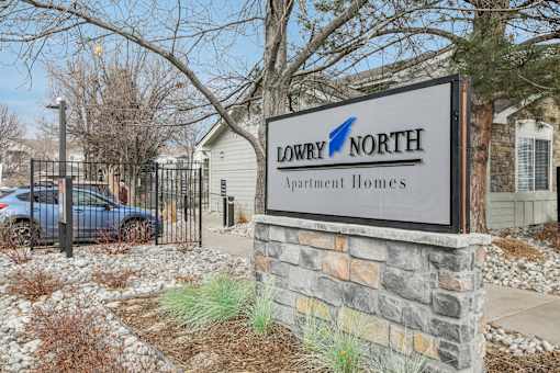 A sign for Lowry North Apartment Homes in front of a gated entrance.