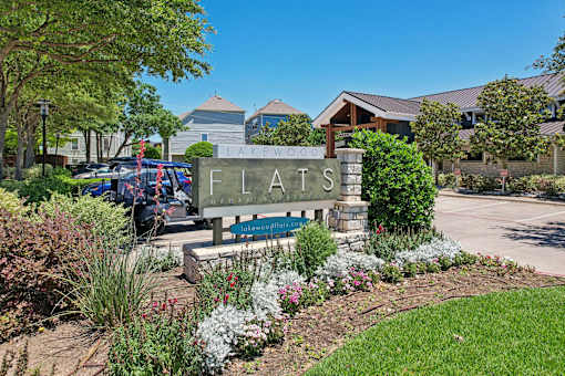 A sign that says Flats in front of a building.