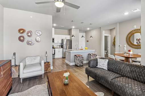 A modern living room with a grey couch, a white chair, and a wooden coffee table.