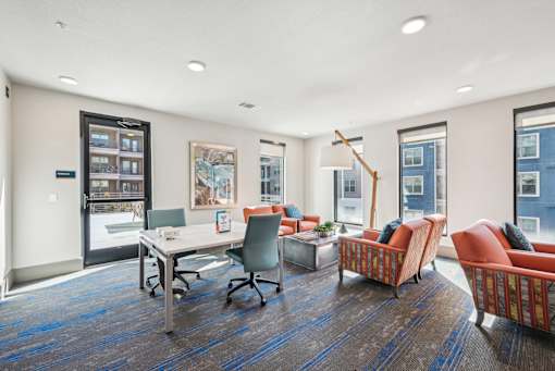 A room with a desk, chairs, and a bookshelf.