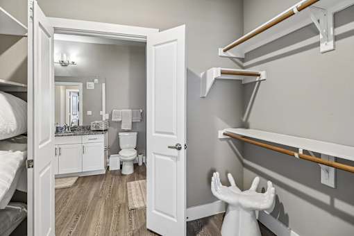 A white toilet is in a small bathroom with a bunk bed.
