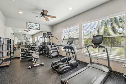 A gym with treadmills, elliptical machines, and other exercise equipment.