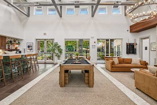 A spacious living room with a pool table in the center.