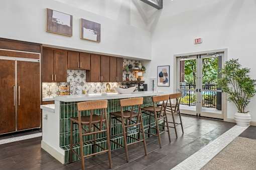 A kitchen with a bar area and a potted plant.
