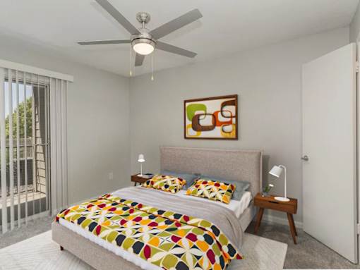 A bedroom with a bed, a ceiling fan, and a painting on the wall.