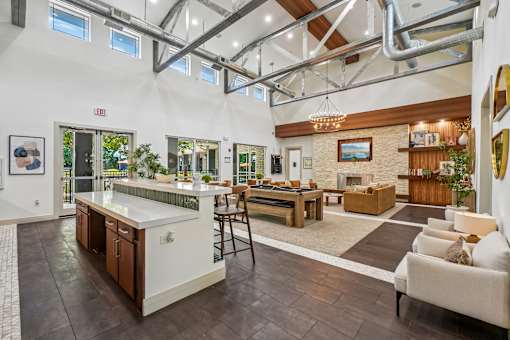 A modern kitchen with a bar area and a living room area.