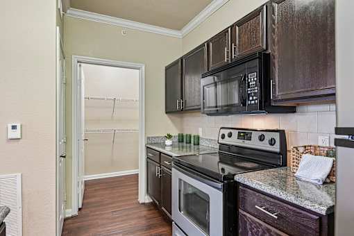 A kitchen with a black microwave above the stove.