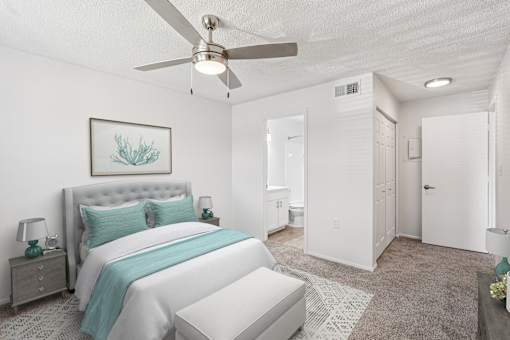 A bedroom with a large bed and a ceiling fan.