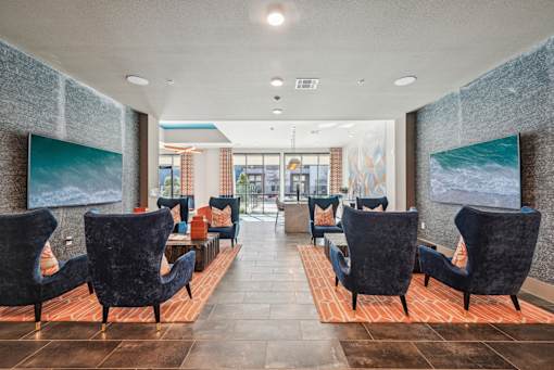 A long hallway with chairs on either side and a painting on the wall.
