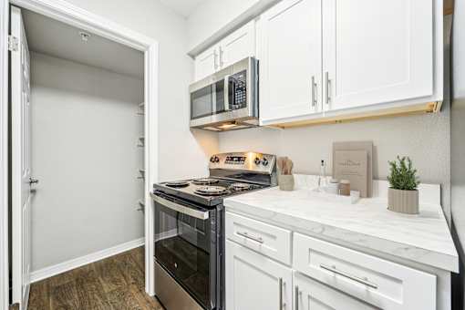 A kitchen with white cabinets and a black stove top oven.