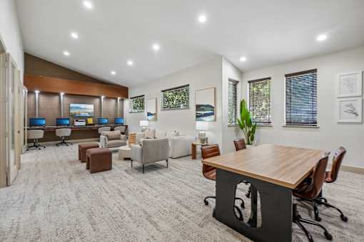A modern office space with a variety of seating options and a long wooden table.