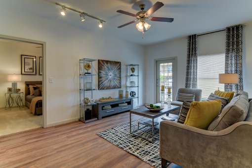 A living room with a brown couch and a ceiling fan.