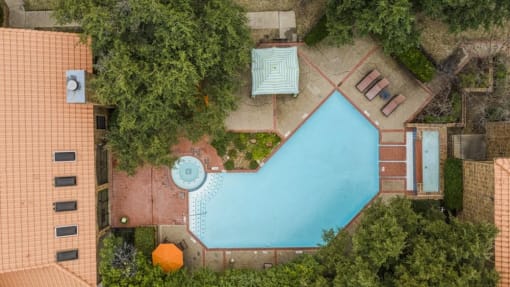 an aerial view of a swimming pool in the backyard of a house