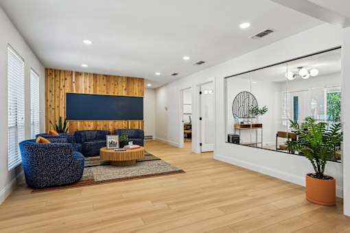 A living room with a blue chair and a wooden wall.