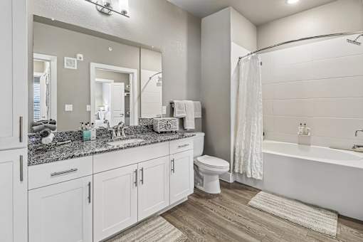 A bathroom with a white toilet, sink, and bathtub.
