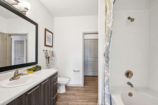 A bathroom with a white tub, sink, and toilet.