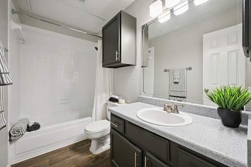 A bathroom with a white tub, toilet, and sink.