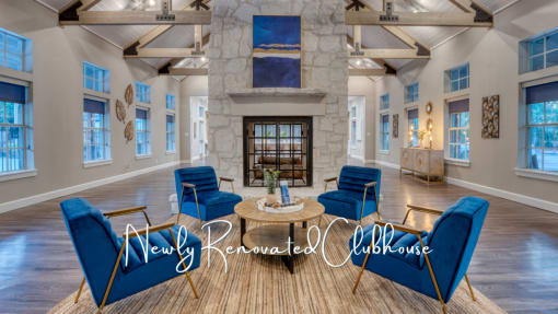 a living room with blue chairs and a fireplace