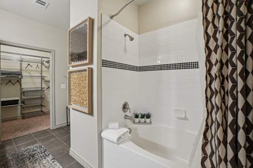 A bathroom with a white tub and a shower.