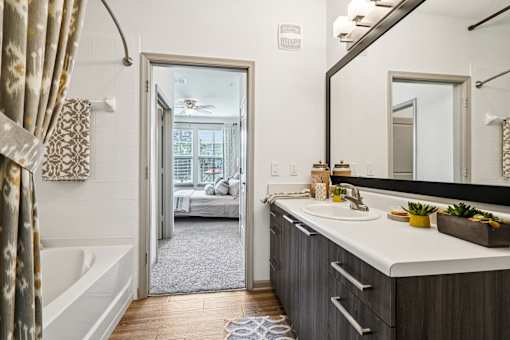 A bathroom with a white tub and sink.
