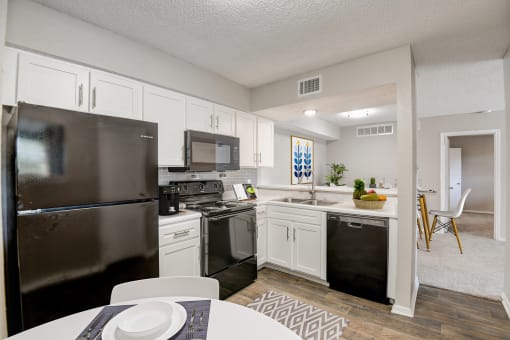 a kitchen with white cabinetry and black appliances