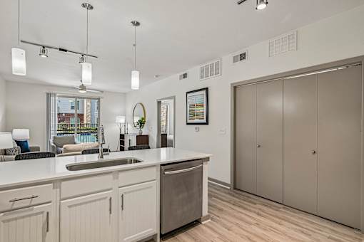 A kitchen with a sink, cabinets, and a window.