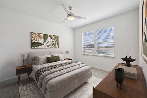A bedroom with a large bed and a ceiling fan.