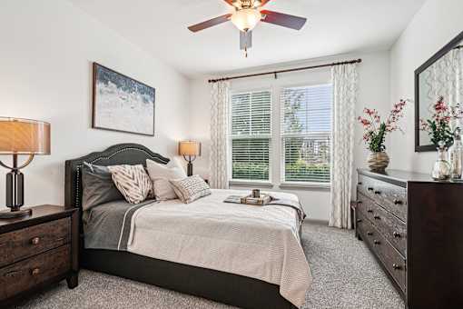 A bedroom with a bed, dresser, and window.