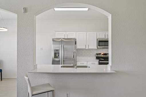 A kitchen with white cabinets and appliances.