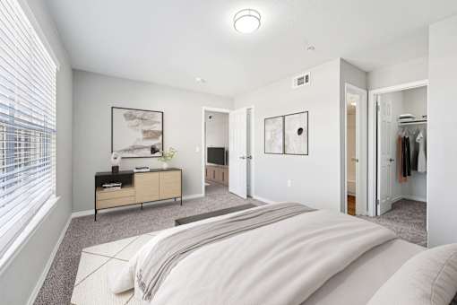 A bedroom with a large bed and a dresser with a mirror.