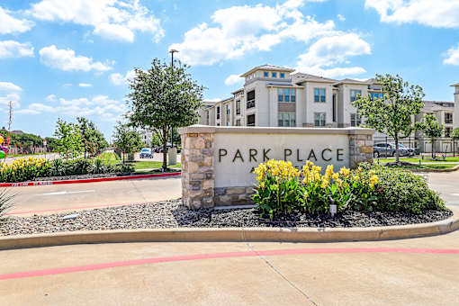 The image shows a sign that says "PARK PLACE" in front of a building.