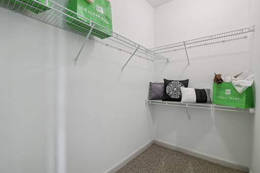 A white closet with a shelf and a green box on top.