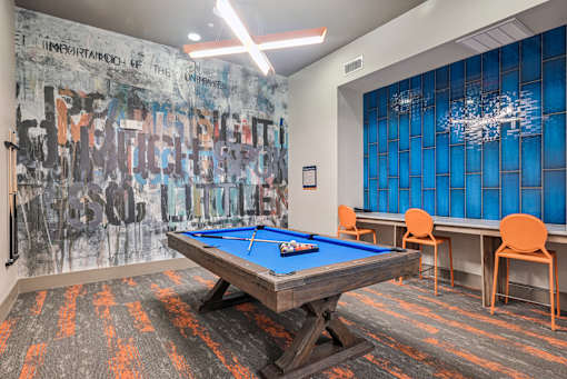 A pool table in a room with a graffiti wall.