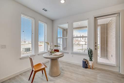 A room with a round table and a chair in it.
