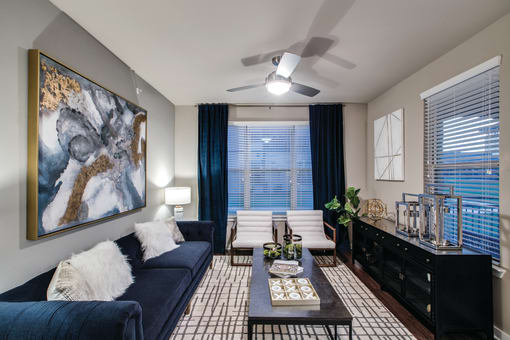 a living room with a blue couch and a large painting on the wall